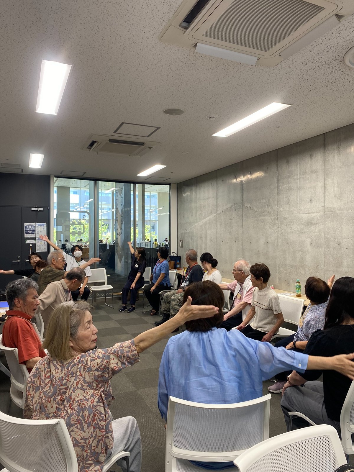 座って腕を伸ばす体操の様子